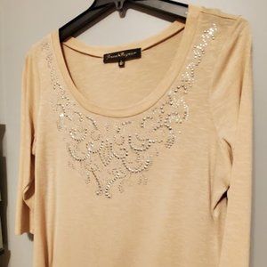 This tunic is beige, a size XL, with Silver detailing around the neckline.